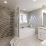 Bathroom remodel with glass shower and recessed lighting.