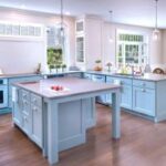 Kitchen remodel with light blue cabinetry, wood floors, and a large island.