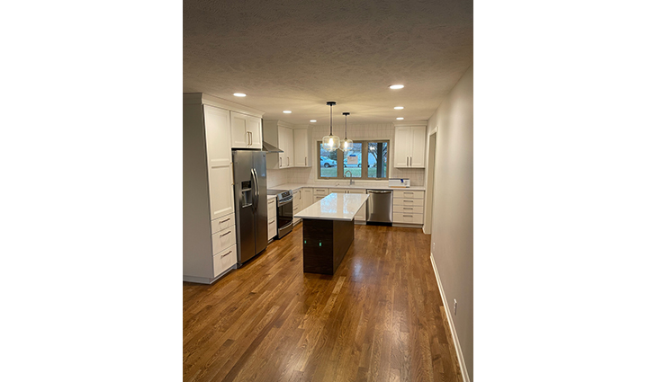Fully remodeled kitchen with hardwood floors and a black island with room for stools