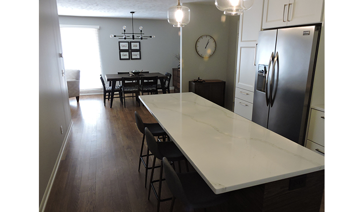 White granite countertop with black chairs in a newly renovated kitchen
