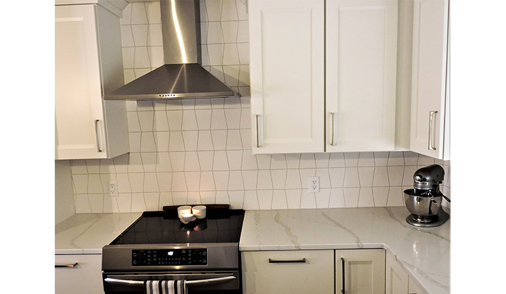 Kitchen remodel with white cabinets and geometric backsplash
