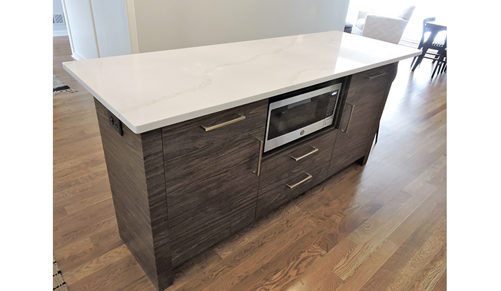 New kitchen island with a microwave inside and six wood cabinets