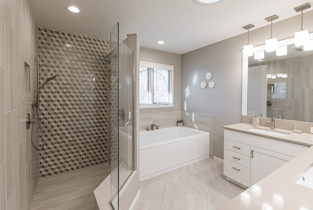 Remodeled bathroom with stand-up shower and separate tub. White tile floor, light gray walls, double vanity, recessed lighting.