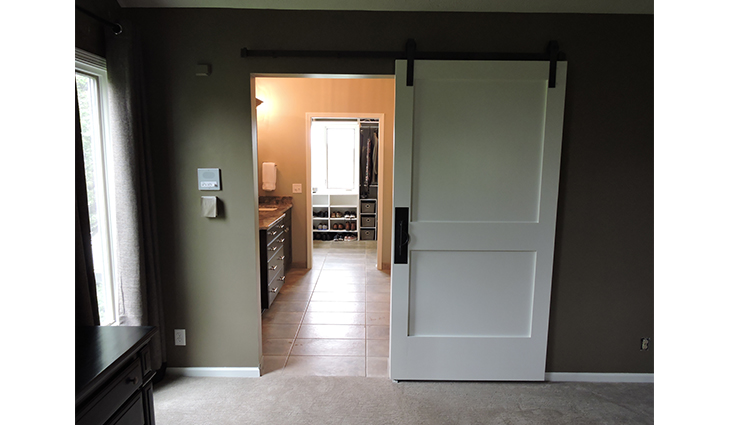 Sliding barn-style door that opens to a walk in closet