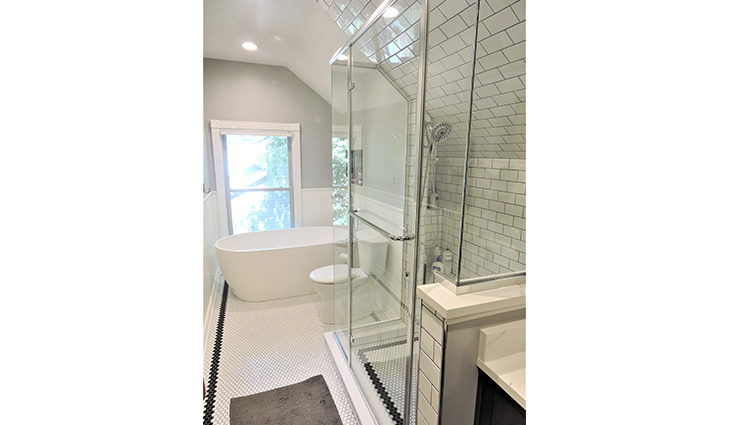Bathroom remodel with an upright glass shower and modern white tub