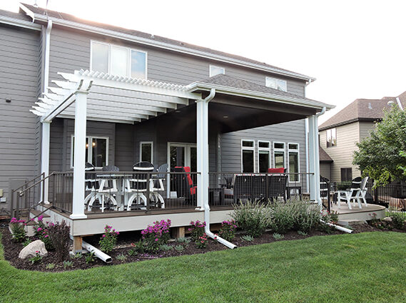 Deck expansion in a gray home's backyard.