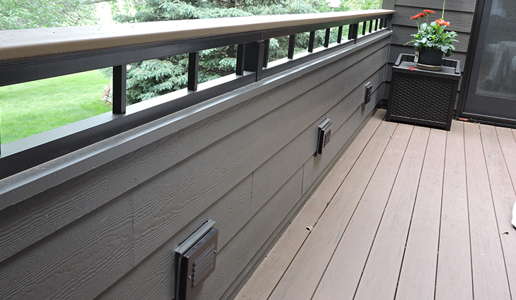 New railing on an outside back porch with vents for heating and airflow