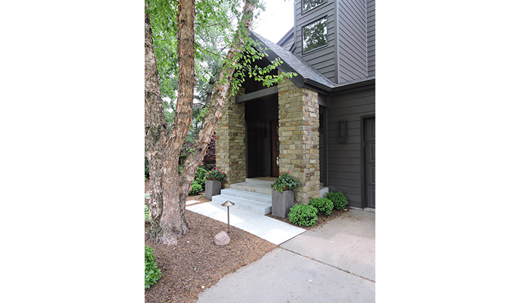 Home exterior with stone columns and gray siding