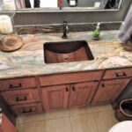 Remodeled bathroom sink with unique stone countertop.