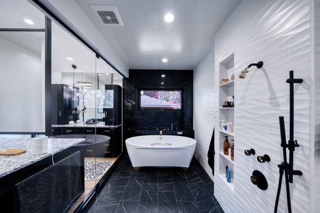 Black and white bathroom with recessed lighting and soak-in tub.