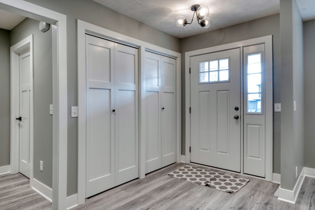 White interior doors in a home with gray walls and gray vinyl plank flooring.