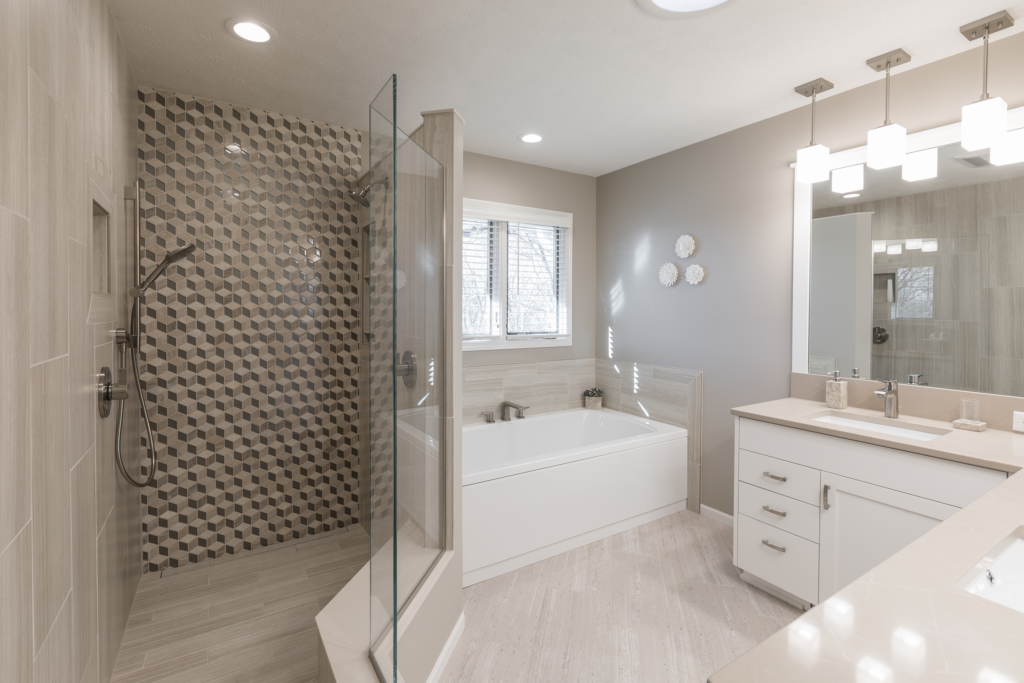 Bathroom remodel with stand-in shower and soaking tub. Light tile floors, white cabinets, dual vanity, light stone countertop.