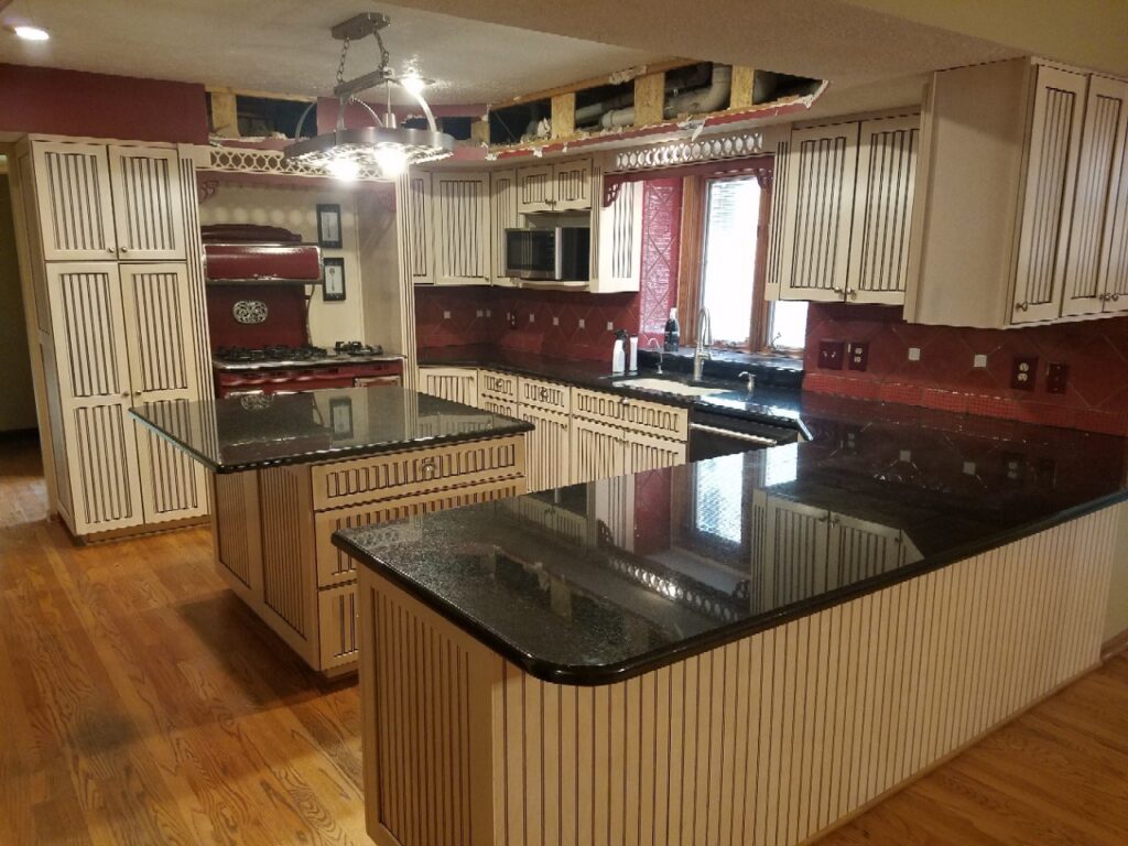 Kitchen with striped cabinets and red backsplash