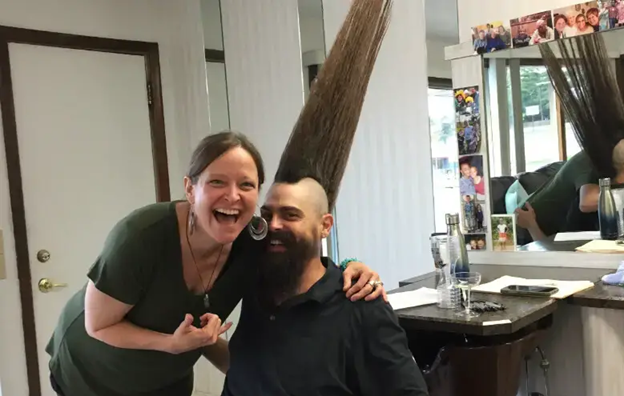 Eric Hahn world record holder for tallest mohawk, smiling next to woman who is laughing and smiling.