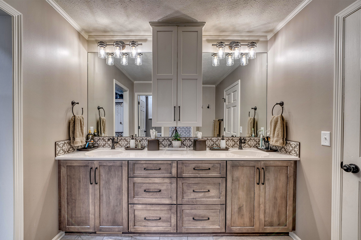 Bathroom addition with two sinks and a large cabinet in the middle