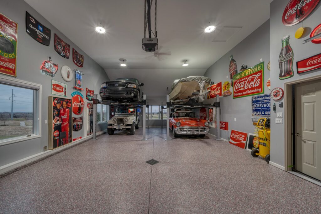 Large garage with three vehicles and a small covered boat. Retro Coca-Cola decor on both walls.