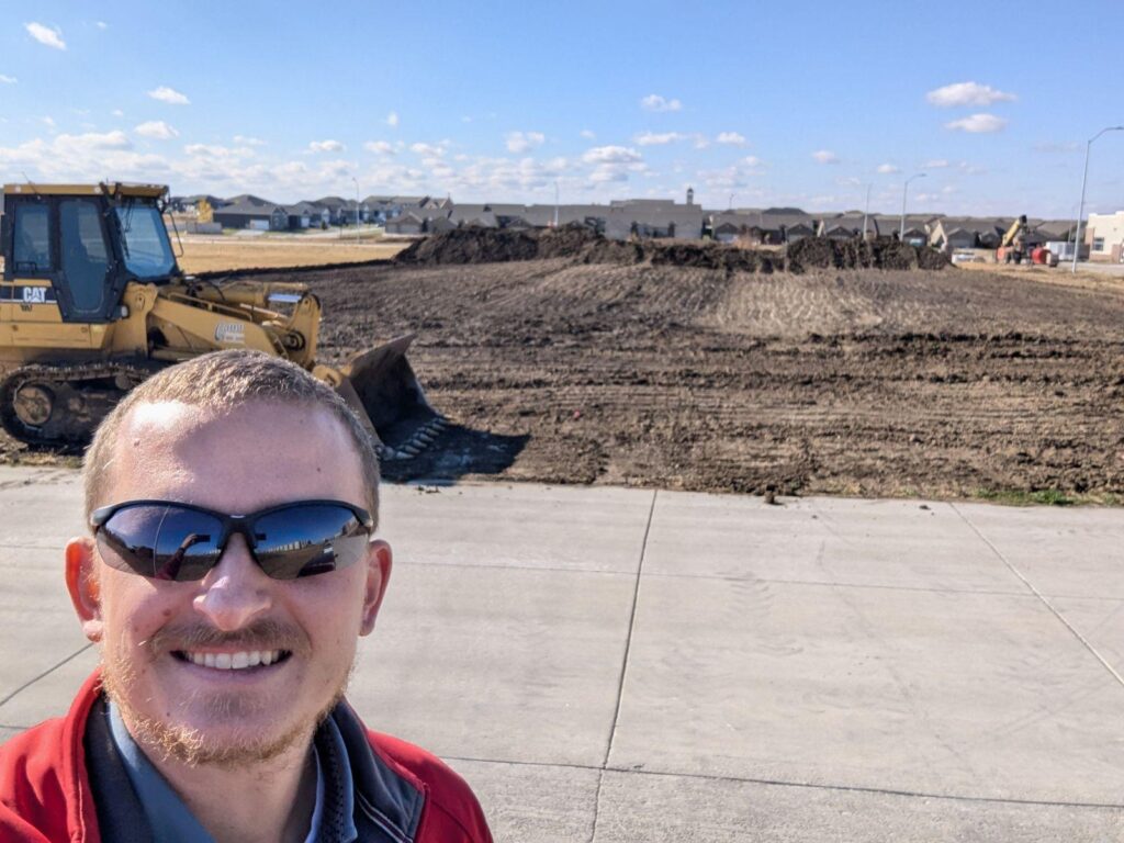 A Willet Construction team member in front of the construction site of the new office