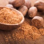 Nutmeg seeds and ground nutmeg in a bowl