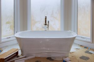 Master bath in bathroom in new luxury house that's under construction with white tub 